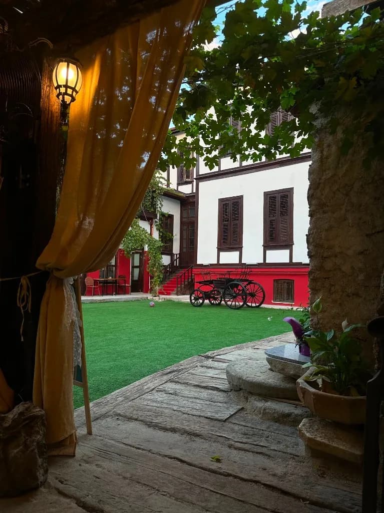 Sarı perde ve fenerli avlu girişinden bahçe