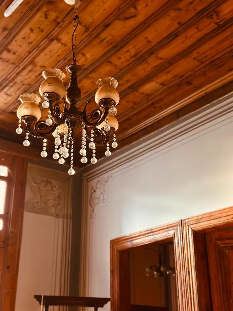 Ahşap tavanlı odada kristalli avize